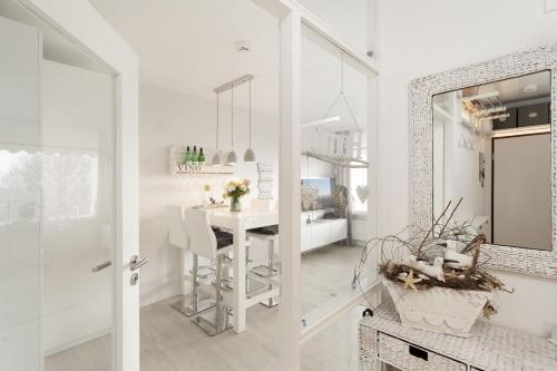 een witte keuken met een tafel en een eetkamer bij Strandappartements am Leuchtturmweg Baltic-View in Kellenhusen