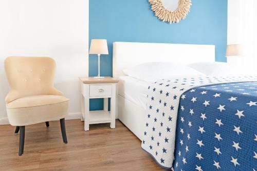 沙博伊茨Haus Meeresstrand Gestrandet的一间卧室，里面有一张床、一把椅子和一张桌子