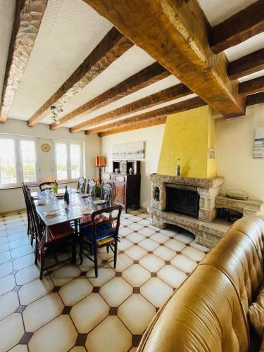 une salle à manger avec une table et une cheminée dans l'établissement Ti Breizh 8 pers 3km de la mer, à Guimaëc