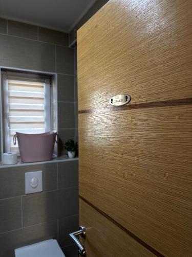 a wooden door in a bathroom with a toilet at Sobe i Apartman R Bileća in Bileća