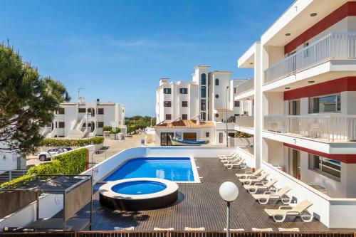 an apartment patio with a swimming pool and lounge chairs at Apartamentos Turisticos Monte da Vinha II in Albufeira