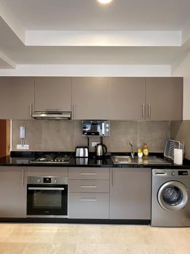 una cocina con estufa y fregadero en Noria Golf Poolside Garden Flat, en Marrakech