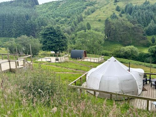 a tent in a field with a mountain in the background at Reservoir View Glamping Pod in Dol-y-gaer Station