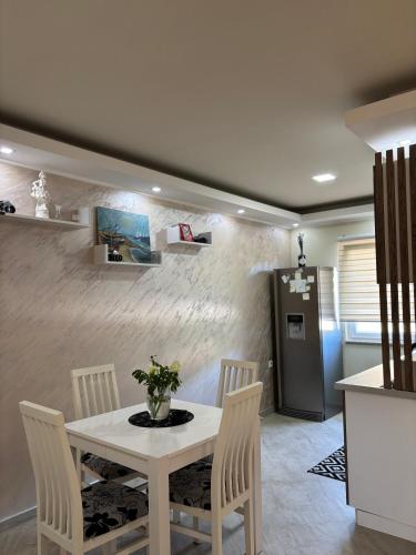 a dining room with a white table and chairs at Sobe i Apartman R Bileća in Bileća