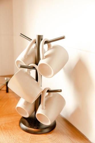 a metal sculpture with white chairs on a wooden floor at Juniorsuite-Apartment Weiden in Weiden