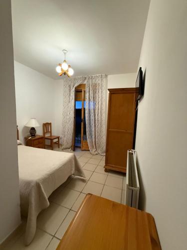 a bedroom with a bed and a table in a room at Nuevo Hostal Rasil in Nohales