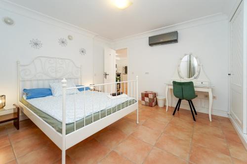 a bedroom with a white bed and a desk at Villa Magnificent 5-star with sea view, jacuzzi and pool in Arguineguín