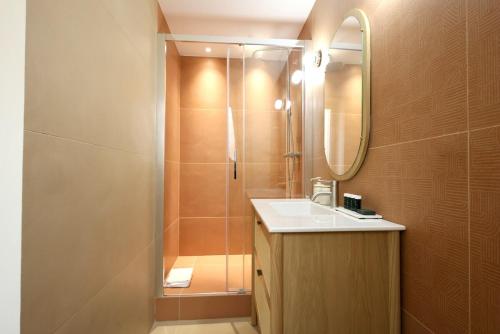 une salle de bain avec une douche, un lavabo et un miroir dans l'établissement Appartement Centre Cannes, à Cannes