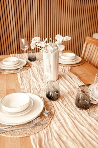 a table with plates and a vase of flowers on it at Juniorsuite-Apartment Weiden in Weiden
