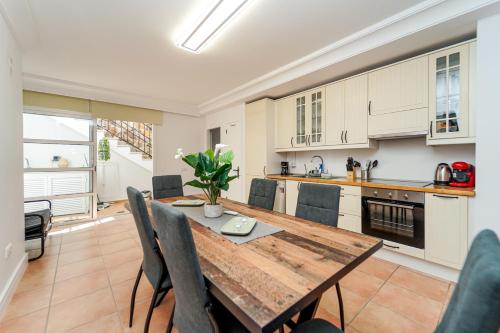a kitchen and dining room with a wooden table and chairs at Villa Magnificent 5-star with sea view, jacuzzi and pool in Arguineguín