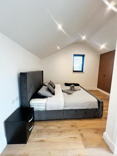 a bedroom with a large bed in a room at Modern Entire Unit 3BR, 3BA, balcony, 86inch TV - 15mins to city in Romford