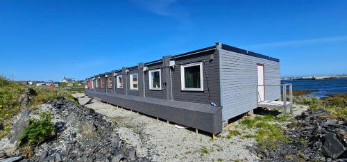 a tiny house sitting on top of a rocky beach at Gamvik brakkebo as in Gamvik