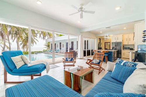 a living room with a blue couch and a table at Belize Oceanfront Villa W Pool, Beach & Pier in Basil Jones