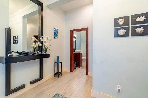 a hallway with a mirror and a table and a sink at Belize Oceanfront Villa W Pool, Beach & Pier in Basil Jones