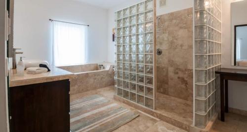 a bathroom with a shower and a sink and a tub at Waterfront 6 Br Villa W Private Plunge Pool in San Pedro