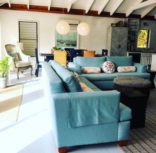 a living room with a blue couch and chairs at Holiday Time Le Reve Beach House & Casita in San Pedro