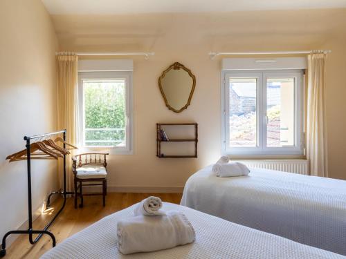 a bedroom with two beds and a mirror at Maison Bretonne Madame est Servie 4 in Perros-Guirec