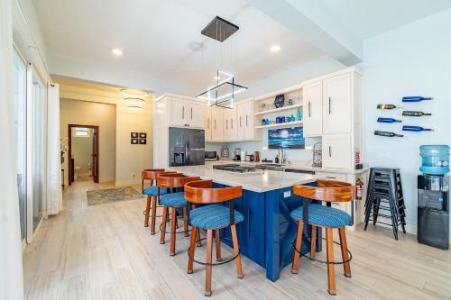 a kitchen with a blue island and wooden bar stools at 4 Br Belize Beachfront Villa W Pool, Beach & Pier in Basil Jones