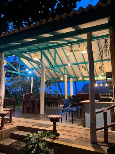 a patio with tables and chairs at night at Beach View in Arugam Bay