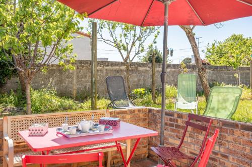 a red table and chairs with a red umbrella at Appartement Entre Mer et Marais in Challans