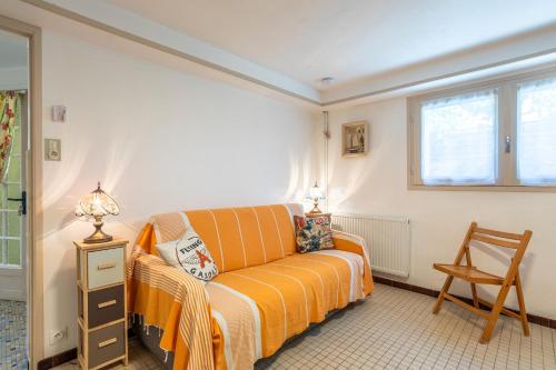 an orange couch in a room with a window at Appartement Entre Mer et Marais in Challans