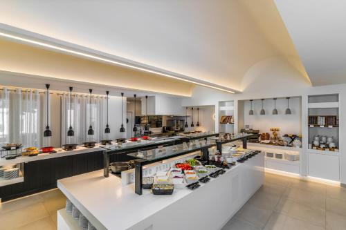 een grote keuken met veel eten bij Costa Grand Resort & Spa in Kamari