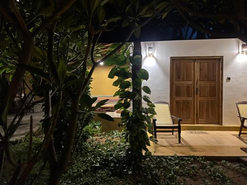 a house with a wooden door and a bench at Beach View in Arugam Bay