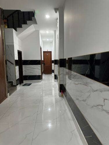 a hallway with black and white walls and a tile floor at Khách Sạn Điểm Hẹn in Ho Chi Minh City