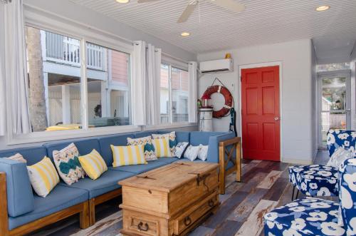 a living room with a blue couch and a red door at Happy Daze by Bryant Real Estate in Kure Beach