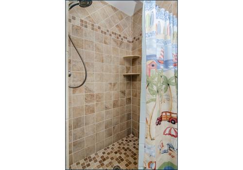 a shower stall with a shower curtain in a bathroom at Happy Daze by Bryant Real Estate in Kure Beach