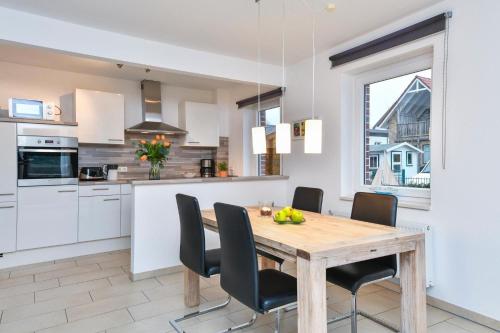 Una cocina y un comedor con mesa y sillas de madera. en Ferienhaus Bootsmann, en Kellenhusen