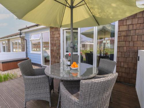 a table and chairs with an umbrella on a patio at Plimoth N6 in Yarmouth