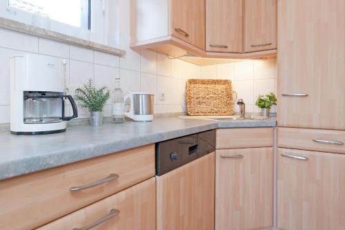 a kitchen with wooden cabinets and a counter top at Haus Matthiesen in Malente