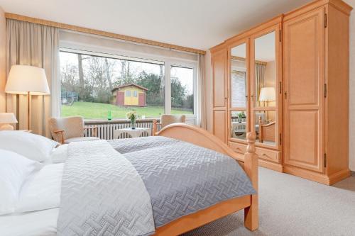 a bedroom with a bed and a large window at Haus Matthiesen in Malente