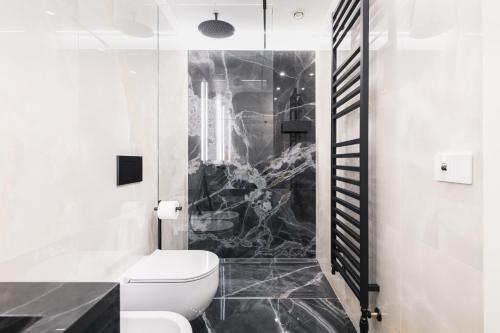 a bathroom with a toilet and a black and white at Easylife - Milano - Medici 5 P2D - Duomo in Milan