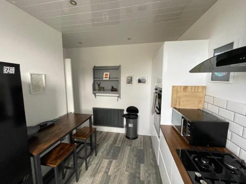 a kitchen with a stove and a counter top at Isle of Bute Blissful Retreat- Stunning 3 Bed Flat in Rothesay
