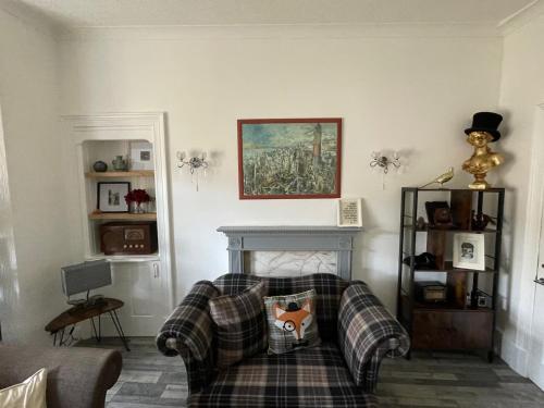 a living room with a plaid couch and a fireplace at Isle of Bute Blissful Retreat- Stunning 3 Bed Flat in Rothesay