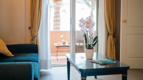 a living room with a couch and a table with flowers on it at Altafiumara Resort & Spa in Villa San Giovanni