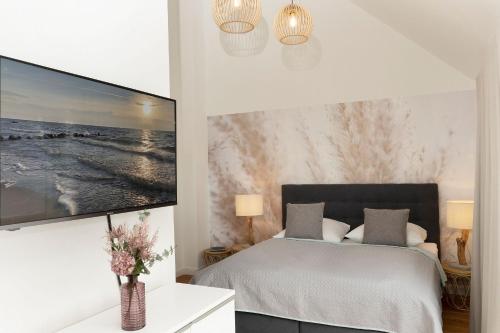 a bedroom with a bed and a large tv on the wall at Meerlust in Scharbeutz