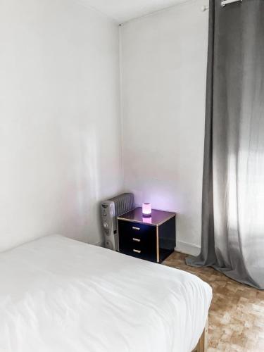 une chambre avec un lit et une table avec une bougie rose dans l'établissement Nice stay near to Paris, à Puteaux