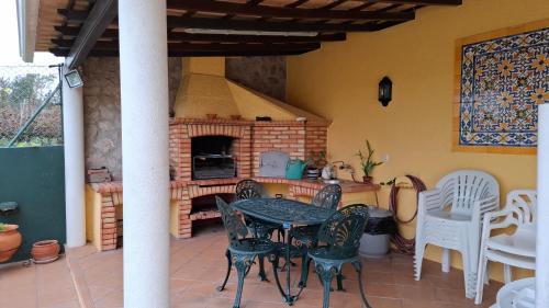 a patio with a table and chairs and a brick oven at Casa da Vinha Azeitão in Azeitao