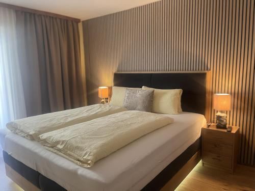 a bedroom with a large bed with two lamps at Gästehaus -Pension Edelweiss in Vent