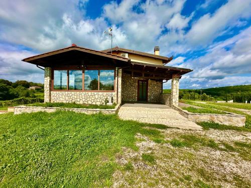 a small building in a grassy field with a sky at Villa Tuscia apartments in Tuscania