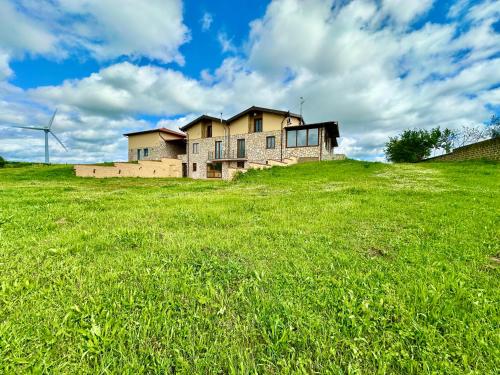 an old house on a hill in a field at Villa Tuscia apartments in Tuscania