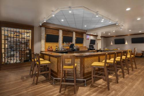 a lobby with a bar with yellow bar stools at Holiday Inn Dubuque/Galena by IHG in Dubuque