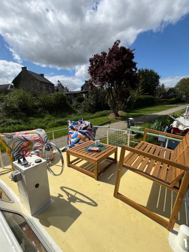 une terrasse avec un banc et une table dans l'établissement Naiade, à Évran