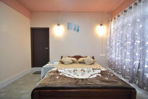 a bedroom with a large bed and a table at Ibawanbet Homestay in Mawphlang