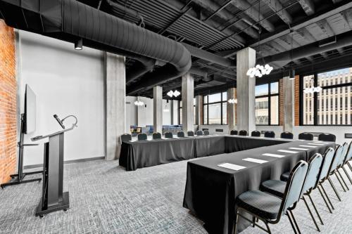 einen Konferenzraum mit Tischen, Stühlen und einem Podium in der Unterkunft Hotel Indigo - Omaha Downtown by IHG in Omaha