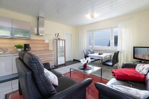 Il dispose d'une cuisine et d'un salon avec un canapé et une table. dans l'établissement Haus Seestern Grömitz Strandglück, à Grömitz