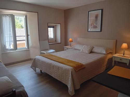 a bedroom with a large bed and two windows at Hôtel La Gravenne in Thueyts